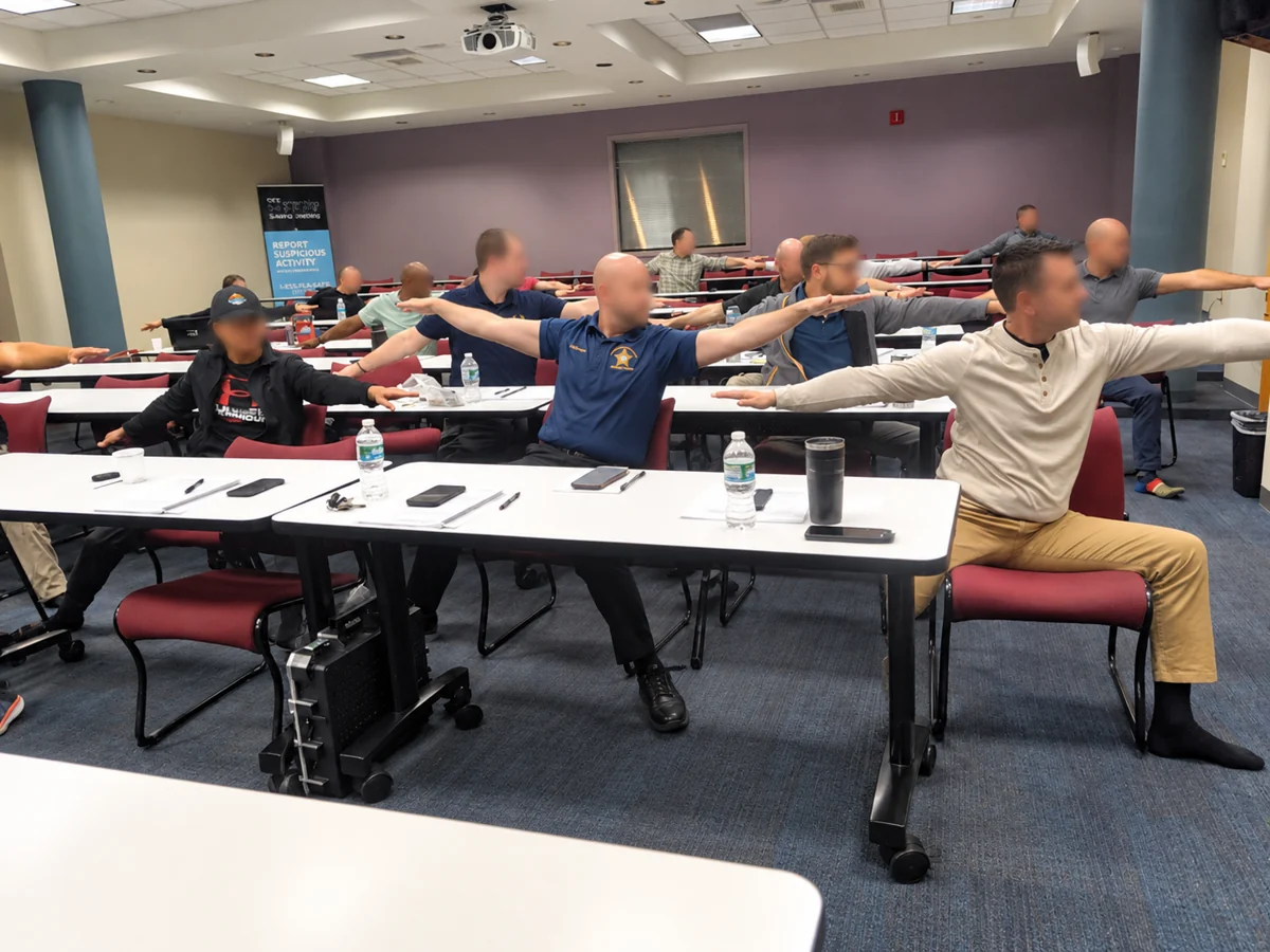 Participants practicing seated chair-yoga stretches during FDLE stress-management training