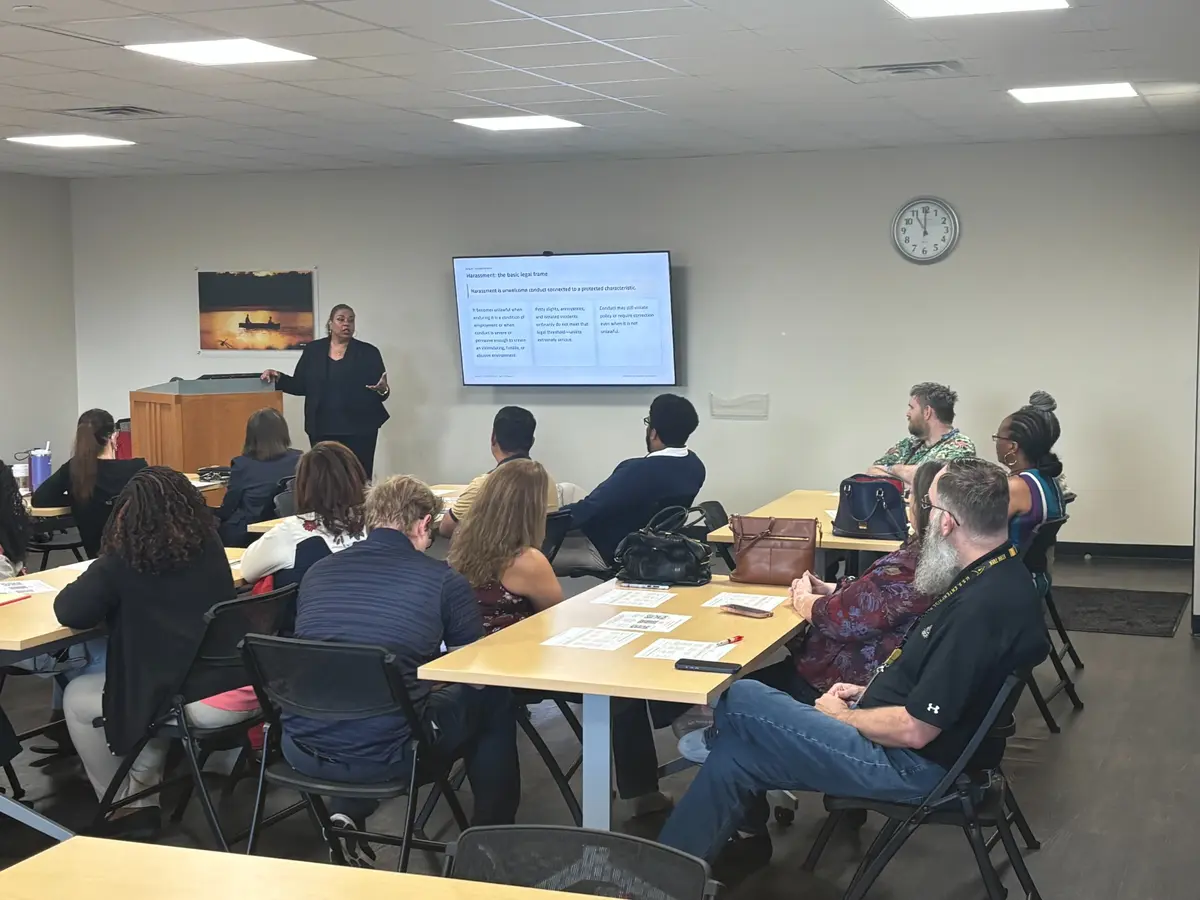 Desirée Nero facilitating a supervisor training session with participants seated around classroom tables